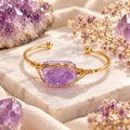 Women’s gold cuff bangle featuring a raw purple amethyst stone wrapped in delicate gold wire on a 304 stainless steel bracelet.