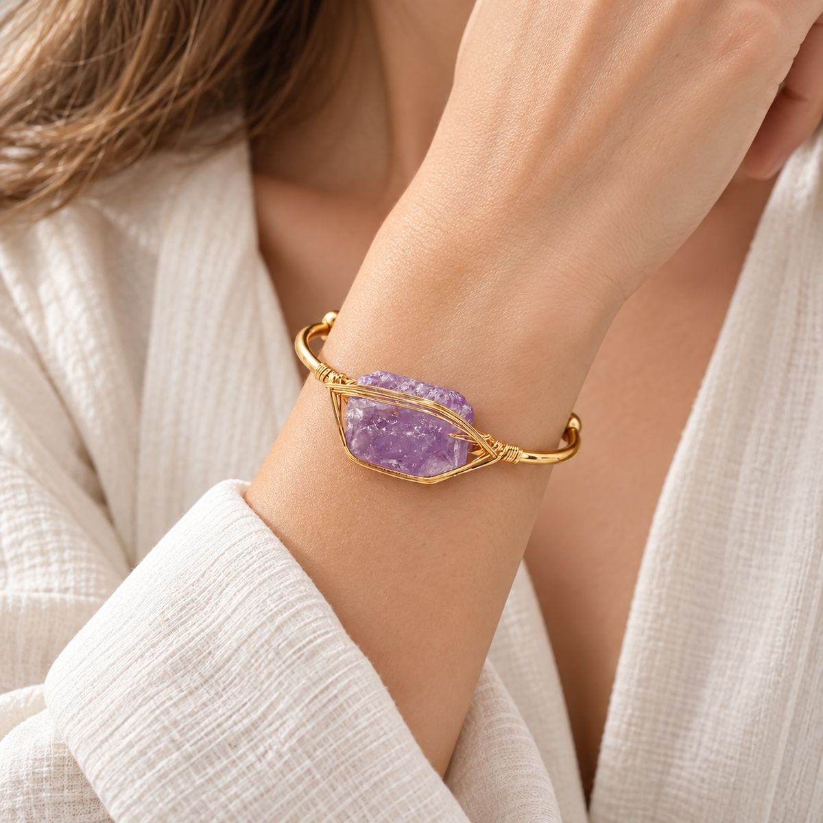 Women’s gold cuff bangle featuring a raw purple amethyst stone wrapped in delicate gold wire on a 304 stainless steel bracelet.
